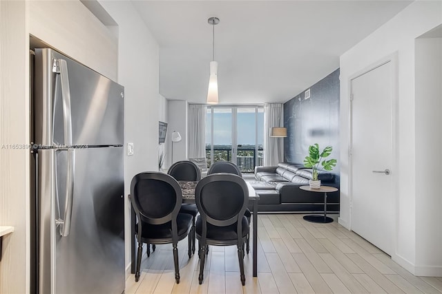 dining room featuring light wood-type flooring and expansive windows