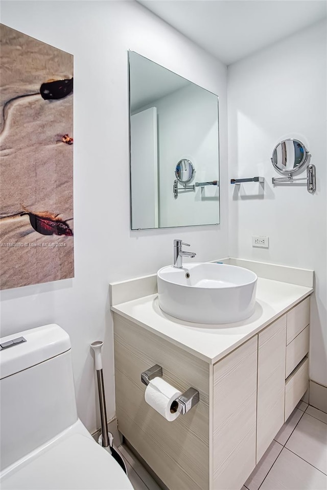 bathroom with tile patterned flooring, vanity, and toilet