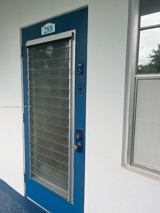 doorway to property featuring stucco siding