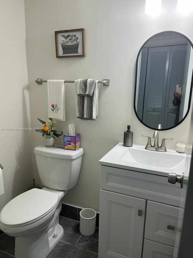 bathroom featuring tile patterned flooring, toilet, vanity, and baseboards
