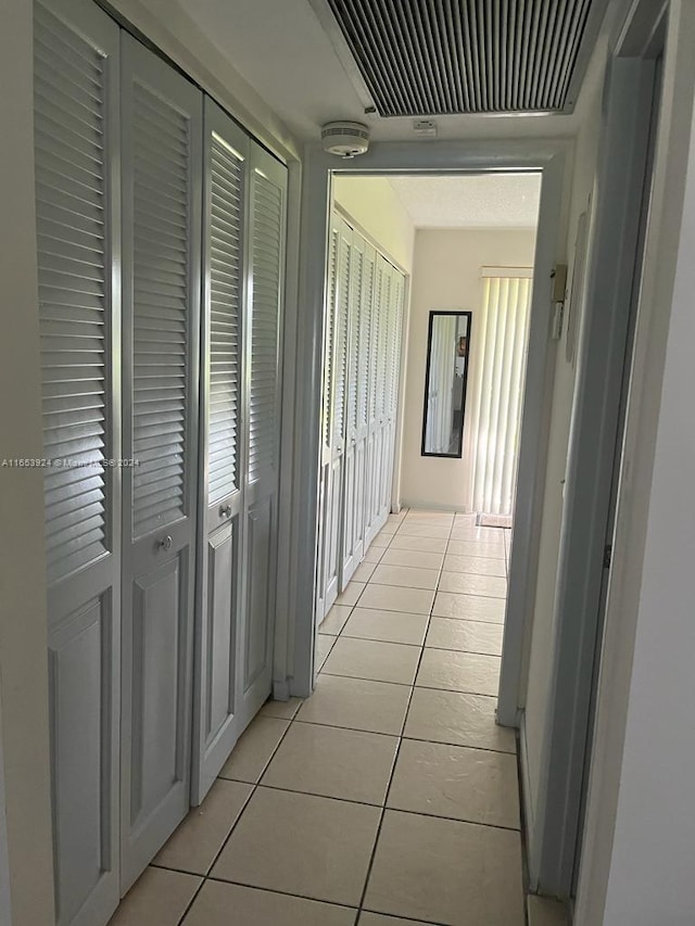 hall featuring light tile patterned flooring