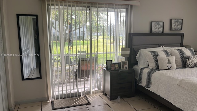 bedroom featuring baseboards, access to outside, multiple windows, and light tile patterned floors