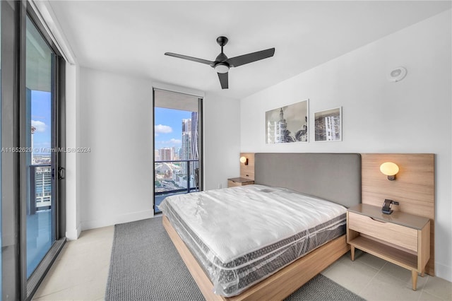 bedroom with a wall of windows, a city view, baseboards, ceiling fan, and access to outside