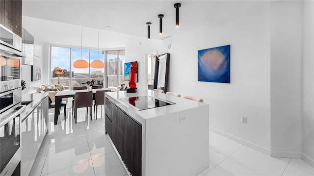 kitchen featuring hanging light fixtures, light tile patterned floors, modern cabinets, and a center island