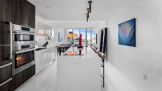 kitchen with light tile patterned flooring, a kitchen island, modern cabinets, and light countertops