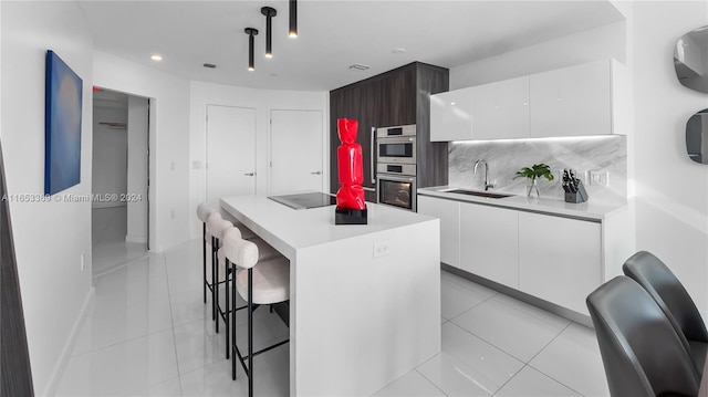 kitchen with a sink, a center island, decorative backsplash, white cabinetry, and modern cabinets