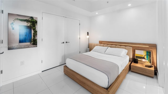 bedroom with light tile patterned floors, recessed lighting, and a closet