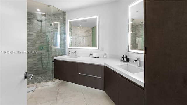 bathroom with a shower stall, double vanity, and a sink