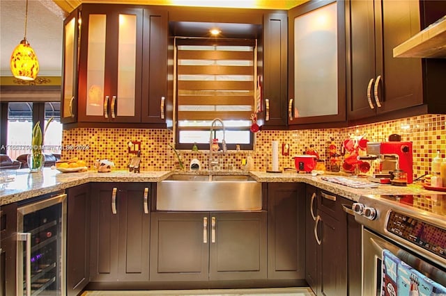 kitchen featuring a wealth of natural light, wine cooler, decorative backsplash, and stainless steel stove