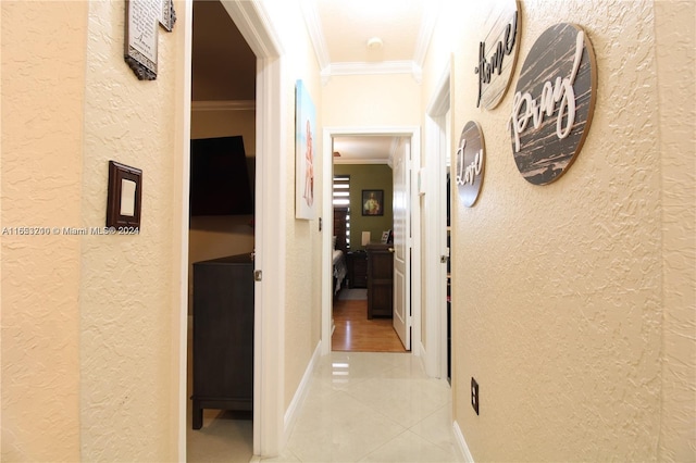 corridor featuring ornamental molding and light tile patterned floors