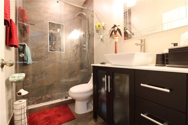 bathroom featuring vanity, toilet, and a shower with door