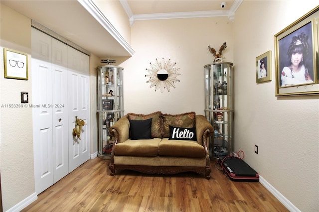 sitting room featuring ornamental molding and wood-type flooring