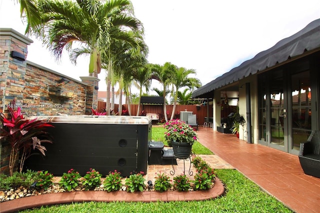 view of yard with a patio, a hot tub, and french doors