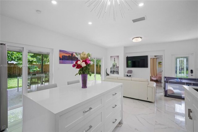 kitchen with white cabinets, a wealth of natural light, and a center island