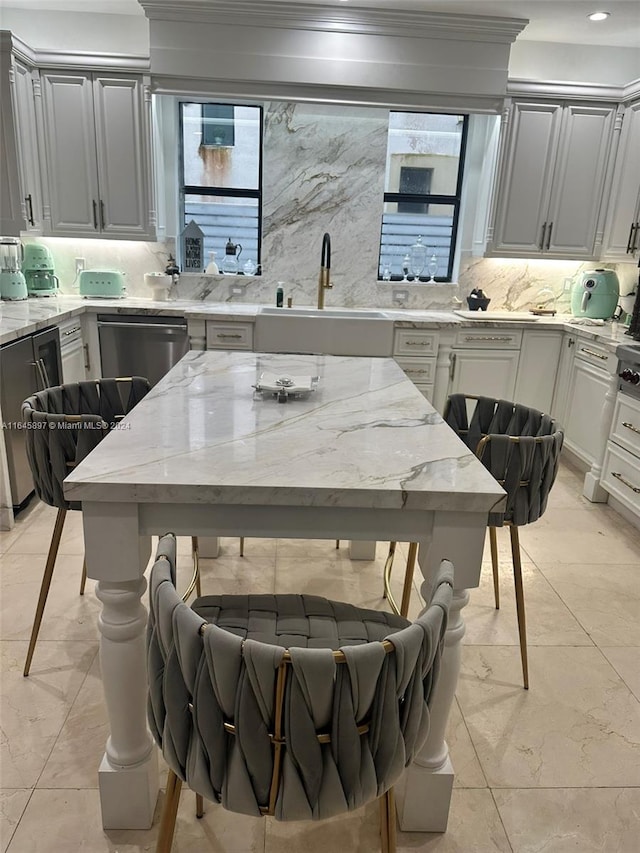 kitchen featuring light stone countertops, stainless steel dishwasher, sink, crown molding, and backsplash