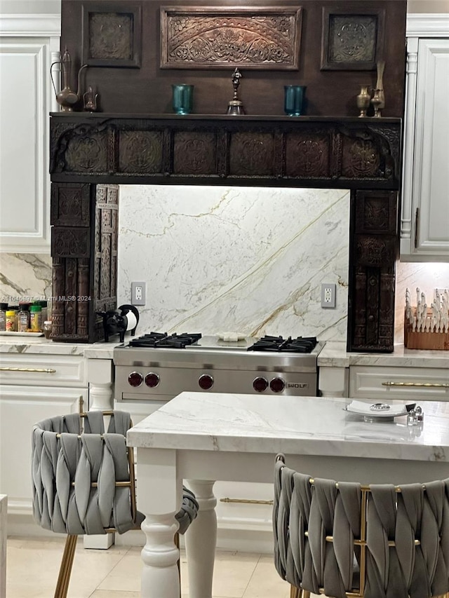 kitchen featuring decorative backsplash, light tile patterned floors, and white cabinets