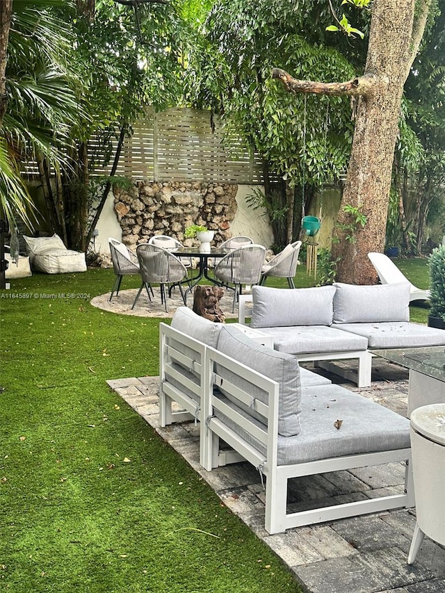 view of community with a patio area, a lawn, and an outdoor living space