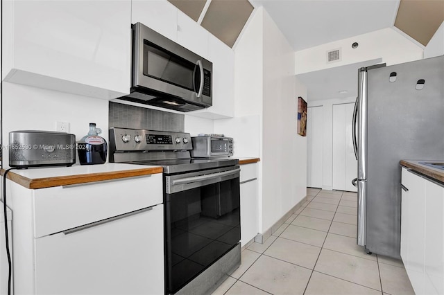 kitchen with appliances with stainless steel finishes, white cabinetry, and light tile patterned flooring