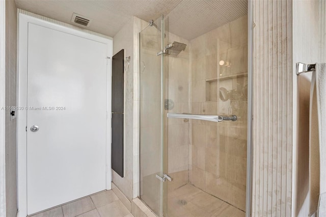 bathroom featuring a shower with shower door and tile patterned floors