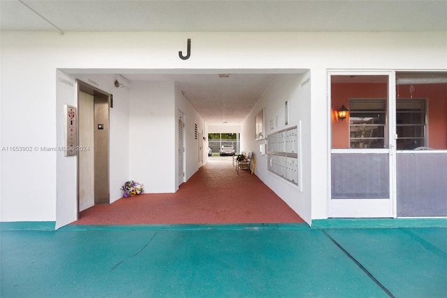 hallway with a mail area and carpet floors