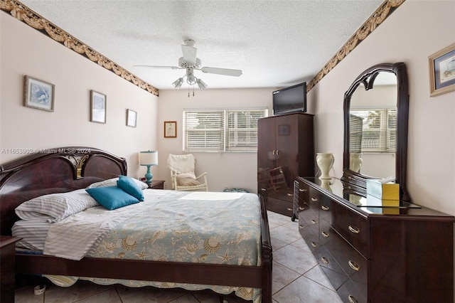 tiled bedroom featuring ceiling fan and a textured ceiling