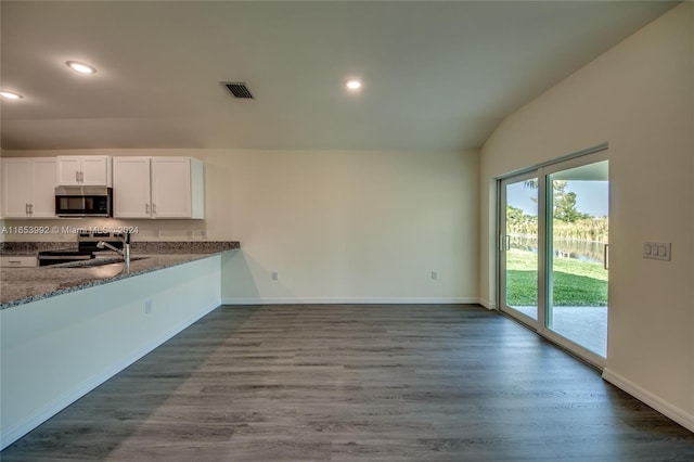 kitchen with hardwood / wood-style floors, white cabinetry, stainless steel appliances, sink, and lofted ceiling