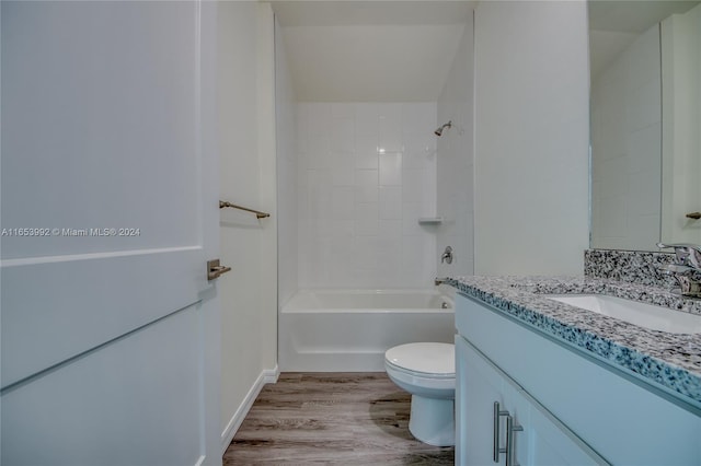 full bathroom with tiled shower / bath, toilet, wood-type flooring, and vanity