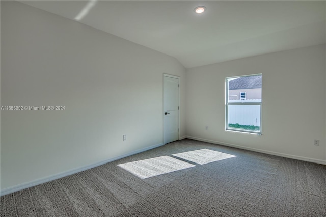 carpeted empty room featuring lofted ceiling