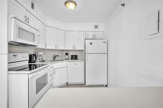 kitchen with white cabinetry, white appliances, electric panel, sink, and light tile patterned flooring