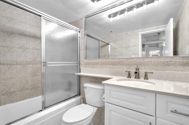 full bathroom featuring toilet, bath / shower combo with glass door, and vanity