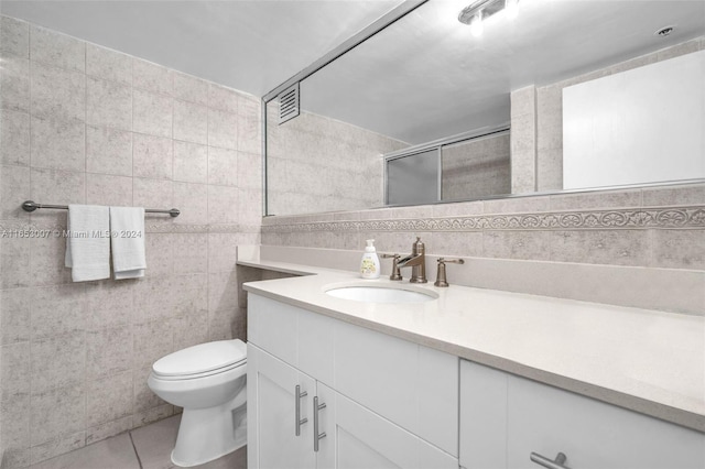 bathroom featuring vanity, walk in shower, tile walls, toilet, and tile patterned floors