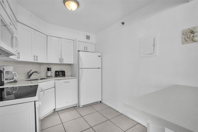 kitchen with sink, light tile patterned floors, white appliances, and white cabinetry