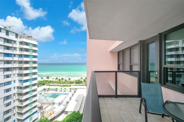 balcony featuring a view of the beach and a water view