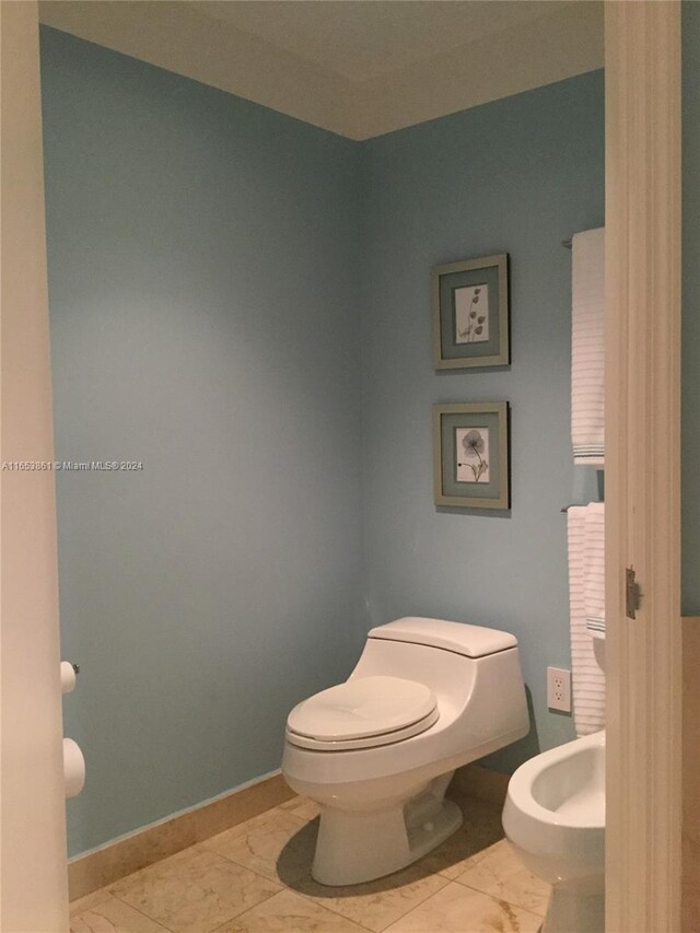 bathroom featuring a bidet, toilet, and tile patterned flooring