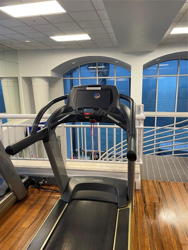 workout area with hardwood / wood-style flooring and a paneled ceiling