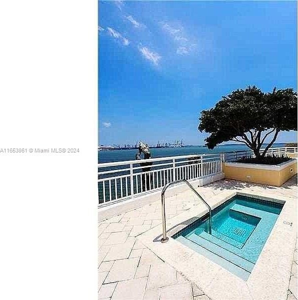 808 Brickell Key Dr Unit 2005, Miami, FL 33131 - view of swimming pool featuring a water view, a patio area, and a hot tub