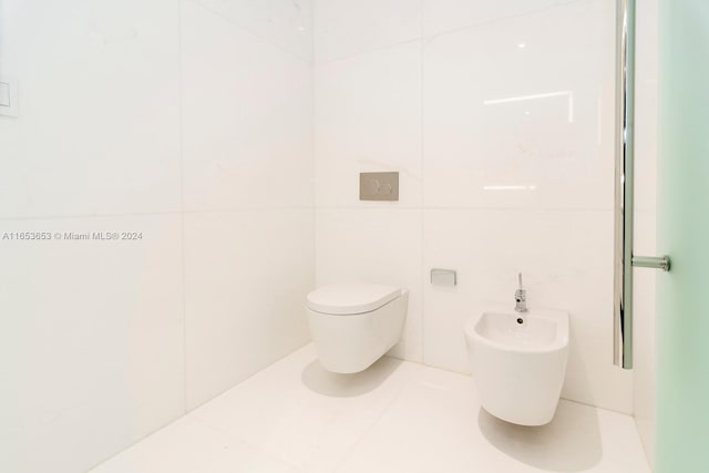 bathroom featuring tile walls, a bidet, and toilet