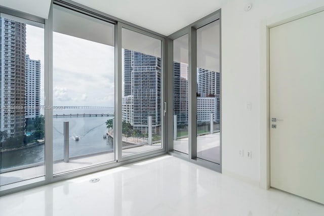 empty room featuring a water view and expansive windows