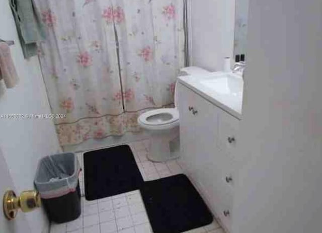 bathroom featuring vanity, toilet, and curtained shower