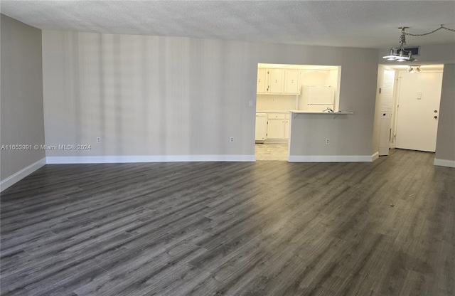 unfurnished living room featuring a textured ceiling and dark hardwood / wood-style flooring