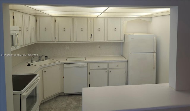 kitchen featuring light countertops, white appliances, and a sink