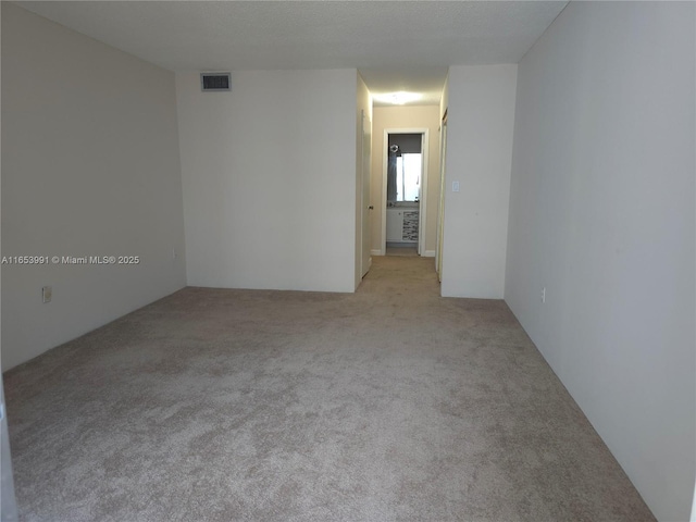 carpeted spare room featuring visible vents