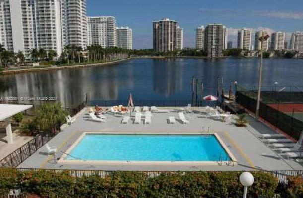 view of pool with a water view and a patio