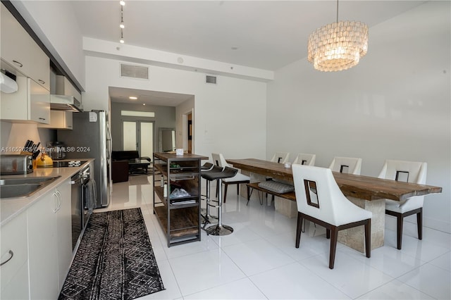 dining space with sink, an inviting chandelier, and light tile patterned flooring