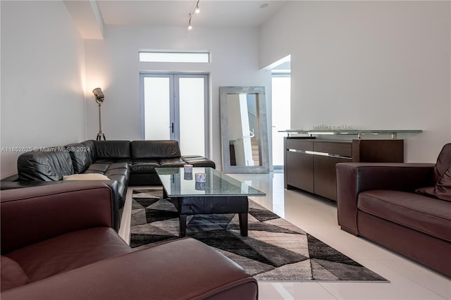 living room featuring rail lighting, light tile patterned floors, and french doors