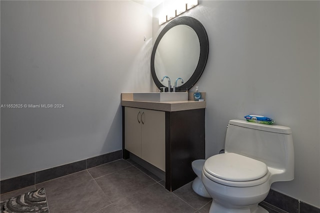 bathroom featuring vanity, toilet, and tile patterned flooring