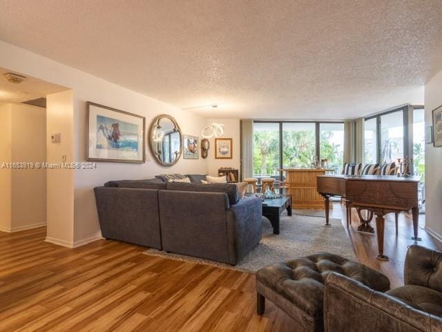 living room featuring a textured ceiling, floor to ceiling windows, and hardwood / wood-style floors