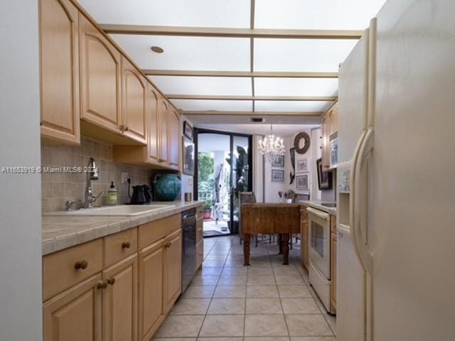 kitchen featuring an inviting chandelier, white appliances, sink, light brown cabinets, and tile counters