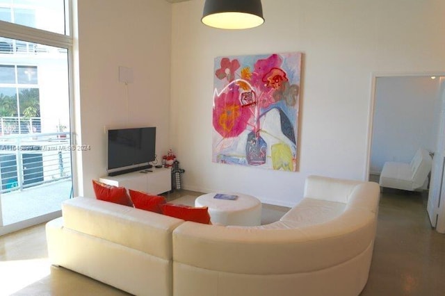 living room featuring concrete flooring and a wealth of natural light