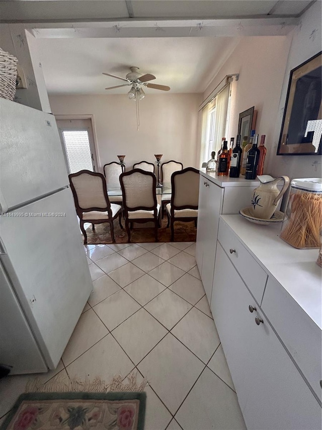 kitchen featuring ceiling fan, white fridge, white cabinets, and light tile patterned flooring